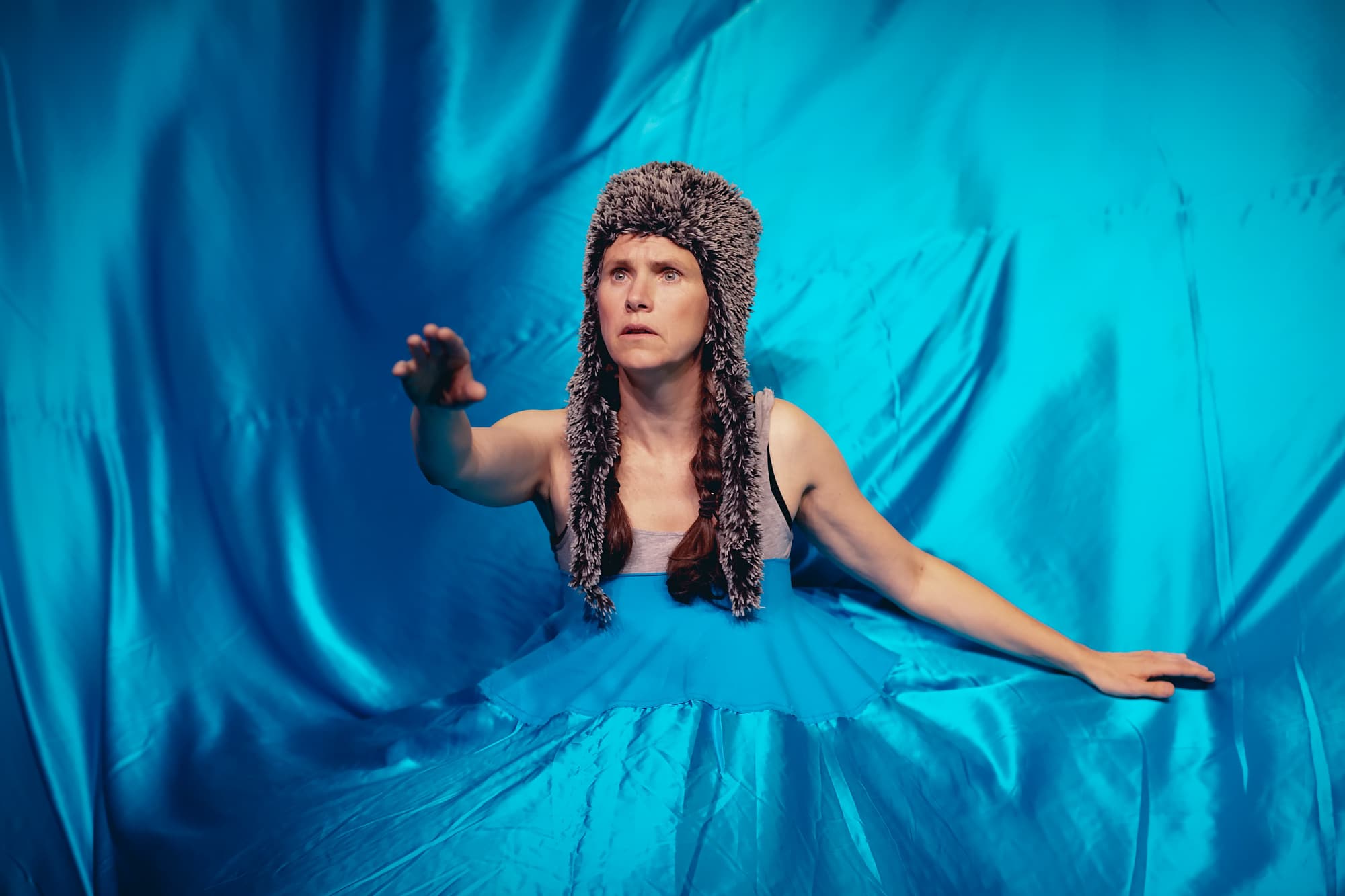 Fotografi: Bildet viser en kvinnelig skuespiller med pelslue ikledd en blå kjole med et slør som omfavner hele bildet.