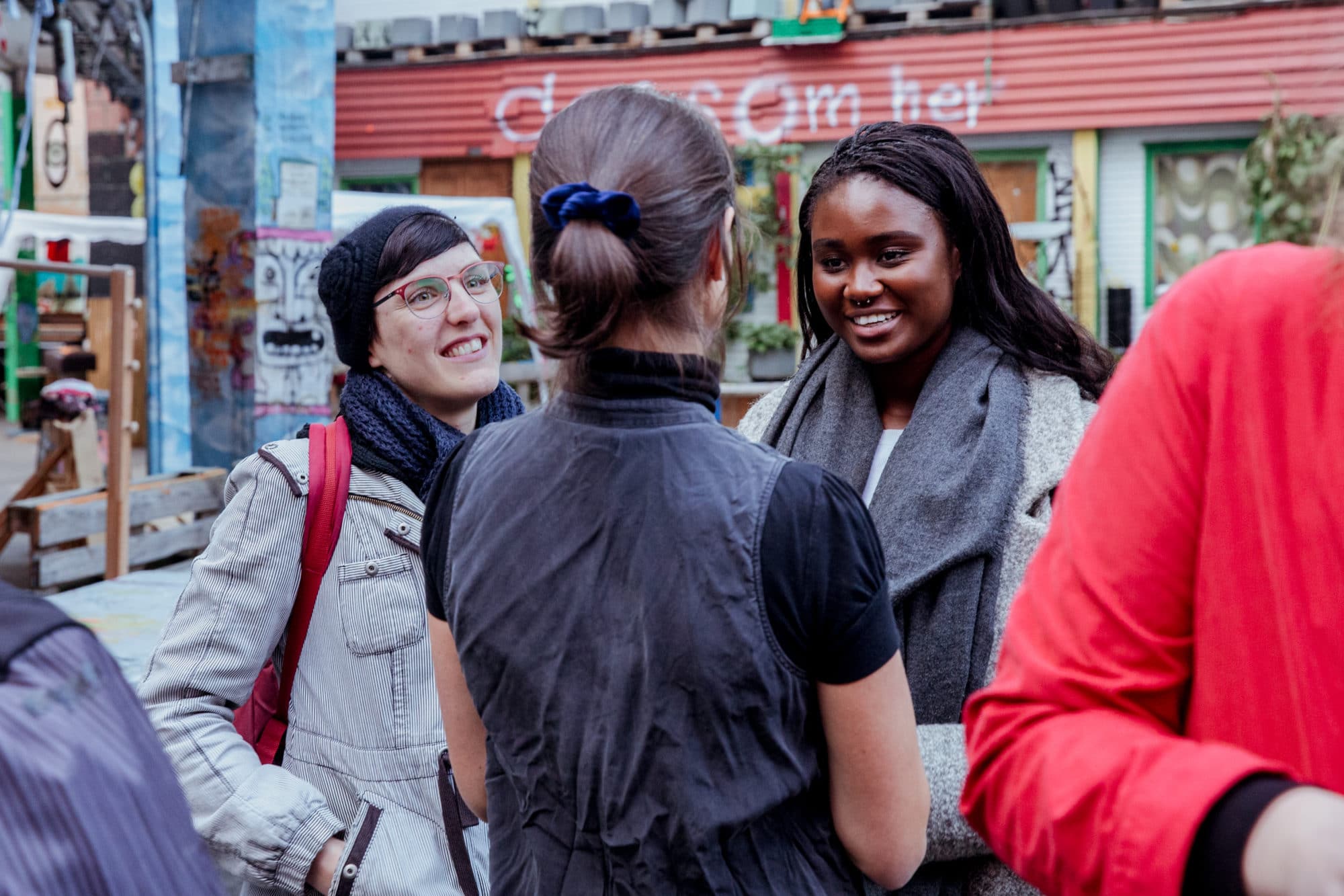 Fotografi. Bildet viser tre unge kvinner som prater sammen.