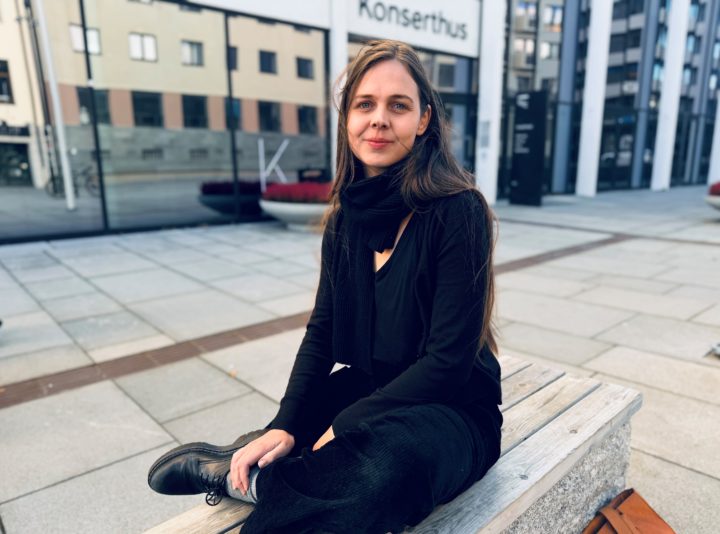 Dramatiker Karoline Una Moen (31) er født og oppvokst i Bodø. Her sitter hun foran utenfor Stormen konserthus i Bodø. Foto: Christine Karijord.