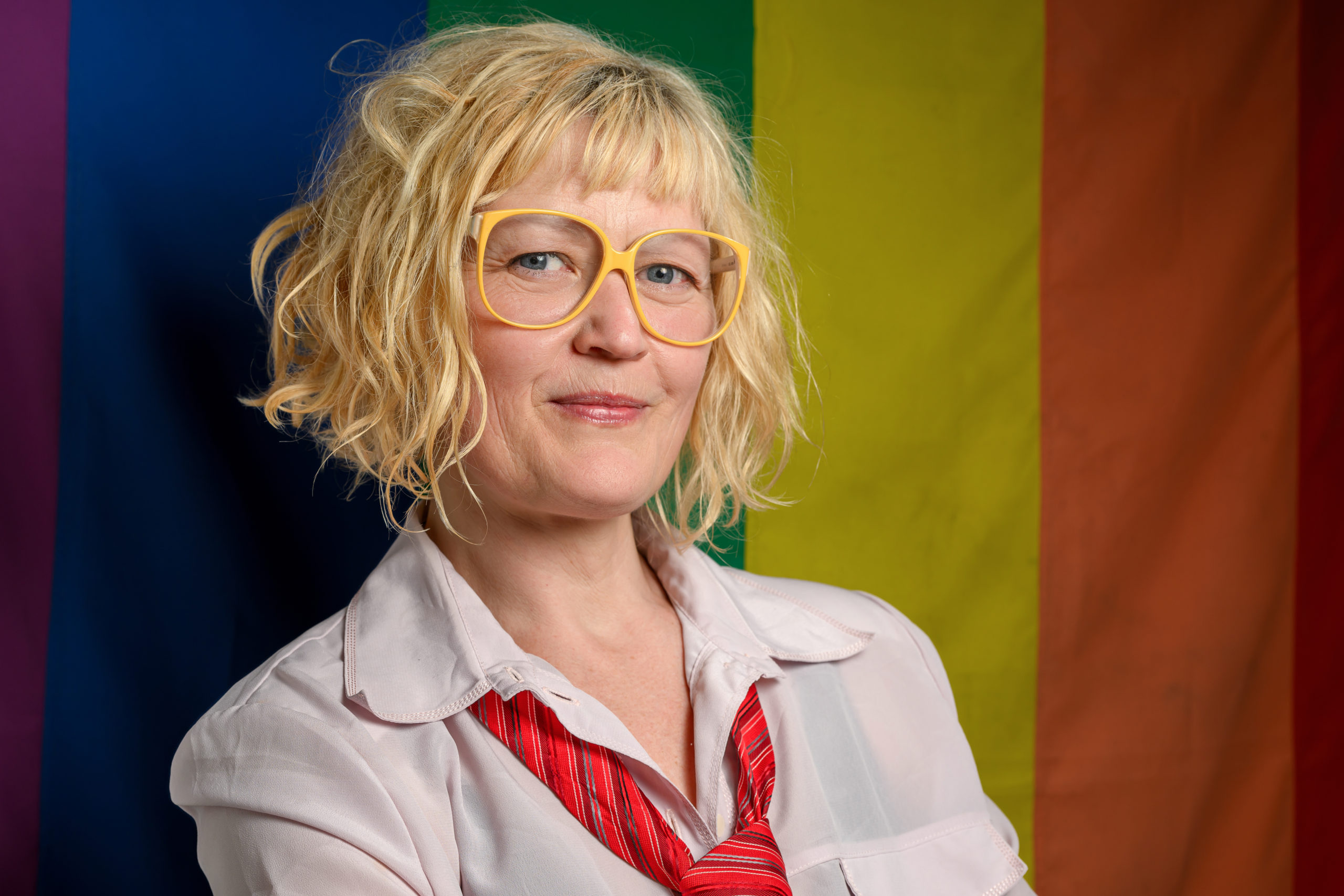 Portrett av Henriette Blakstad foran et Pride-flagg